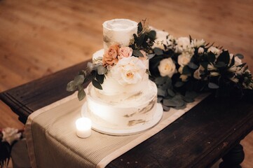 Canvas Print - three layers cake with flowers on table in room with wood floors