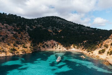 Poster - Aerial view of a small boat with a picturesque backdrop of buildings in Mallorca, Spain