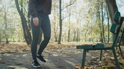 Wall Mural - Tilt up of ginger woman warming up before running at the park in autumn. Shot with RED helium camera in 8K. 