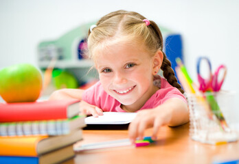 Wall Mural - little girl at the desk with colorfull pens