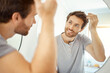 © HockleyMedia/peopleimages.com - Bathroom, mirror reflection and happy man with hair care routine for maintenance, beauty process or hygiene cleaning treatment. Smile, morning and home person style locks for clean shampoo hairstyle