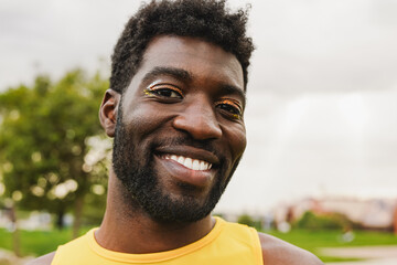 Young gay african man with make up smiling on camera