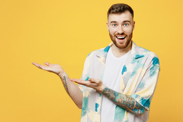 Wall Mural - Young surprised man wear blue shirt white t-shirt casual clothes point hands arms aside indicate workspace area copy space mock up isolated on plain yellow background. Tattoo translates life is fight.