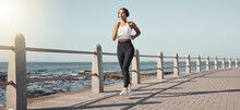 Fitness, Woman Run At Beach And With Headphones Listening To Music For Health Wellness. Training Or Exercise, Marathon Or Lens Flare And Female Person Running Along The Promenade Listen To Radio