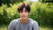 © Tuyres - Portrait of a fictional young Korean man wearing casual clothes in a park. Generative AI illustration.