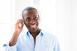 © Aila Bevan/peopleimages.com - Music, black man with headphones and happy listening to radio at his home. Podcast or audio, wellness playlist or positivity and African male person streaming media with smile for connectivity
