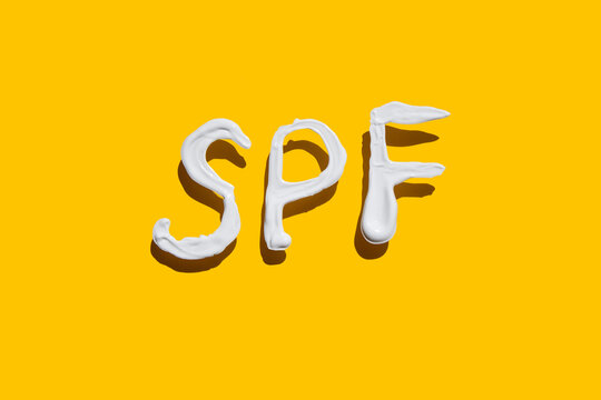 the inscription SPF written in sunscreen on a yellow background