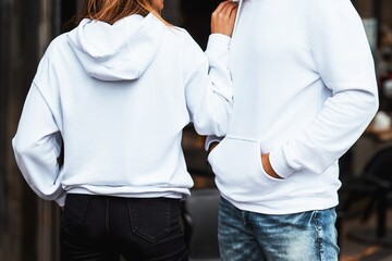 Wall Mural - Basic clothing brand mockup. Design template for hoodie and casual sportswear. A woman and man wearing hoodies with no logo. Horizontal sweatshirt mock-up