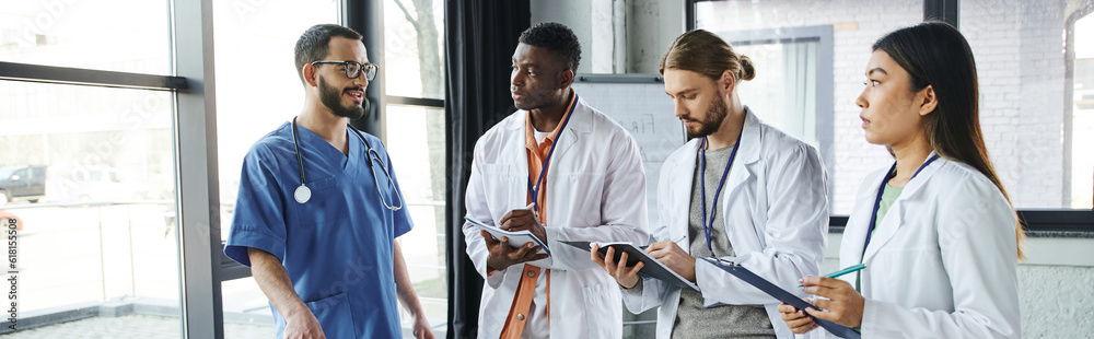 Medical Instructor young and diverse group of multicultural students in white coats ...
