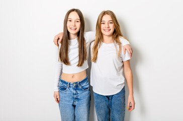 Two Young pre teen best friend girl on studio white