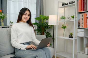 asian girl happy freelancer smiling looking at camera Have a laptop to work at home