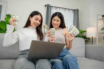 A two Asian freelance female who are happy and happy to earn money from online work earn money from home Successful businessman earning euros from laptop professionally happy