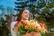 Girl, flowers, spring, outdoors. Spring concept. Beautiful woman summer smiling happy with flowers. Woman with lots of freshly picked up colorful lush amaranth flower. Bouquet of colorful flower