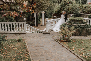 Wall Mural - Wide Plan photo of the bride and groom in the garden near the flowerbed, free space