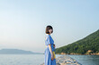 © peach100 - 夕暮れの海にいる青いワンピースの女性