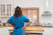 Back of Asian young woman housekeeper in apron preparing and cleaning kitchen room at home