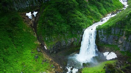 Wall Mural - Beautiful waterfall in Kamchatka peninsula, Russia. Aerial drone view. Green hills and mountains with fresh green grass. Beautiful summer landscape
