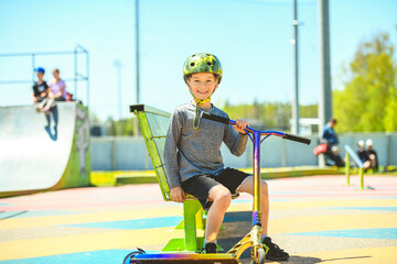 Wall Mural - boy with helmet riding his scooter on a sunny day