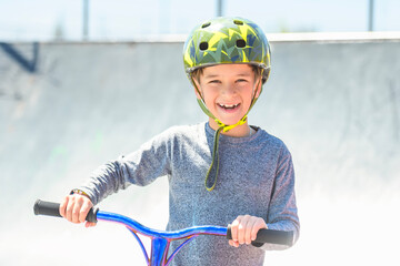 Wall Mural - boy with helmet riding his scooter on a sunny day