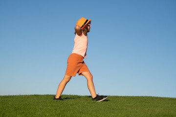 Sticker - Kid boy running on green grass near blue sky in spring park. Morning running with children. Child runner running in the nature. Morning jogging. Active healthy kids lifestyle.