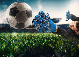 Close up of a goalkeeper catching the ball in the stadium during a football game