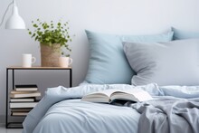 An Open Book On Bed, Bed Covered With Blue Pillows