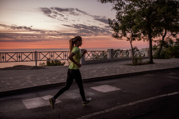  Young woman in sportswear runs along path at dawn. Morning routine, meditation, feeling of freedom