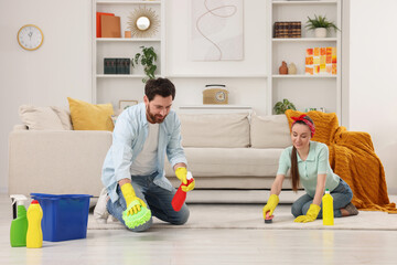 Canvas Print - Spring cleaning. Couple tidying up living room together