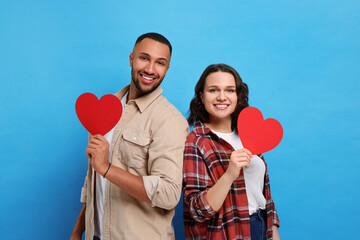 Poster - Lovely couple with red paper hearts on light blue background. Valentine's day celebration