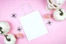Halloween Treat Bag Mockup. Pink Background New Season Colors. Trick Or Treat Party Supplies Stationery Styled With White Skull, Pumpkins, Black Spiders, And Spooky Cupcakes. Negative Copy Space.