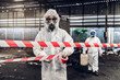 © kanpisut - Scientist wear Chemical protection suit check danger chemical, working at dangerous zone in Red and White Lines of barrier tape. Red and white Hazardous restricted area factory safety worker industry