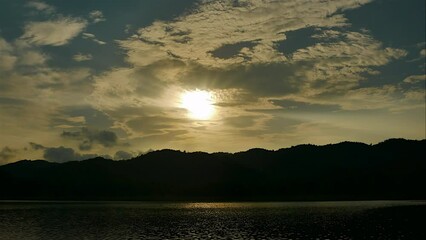 Wall Mural - Time-lapse of Clouds fast in the sky and sunset on a large natural or artificial lake used as a source of water supply.
