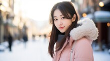 Japanese woman in a light pink coat is walking down the street on a bright winter afternoon. The background is a snowy landscape.