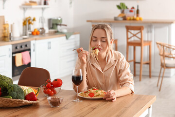 Sticker - Young woman eating tasty pasta in kitchen