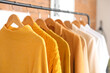 © Pixel-Shot - Rack with stylish female sweaters in modern boutique, closeup