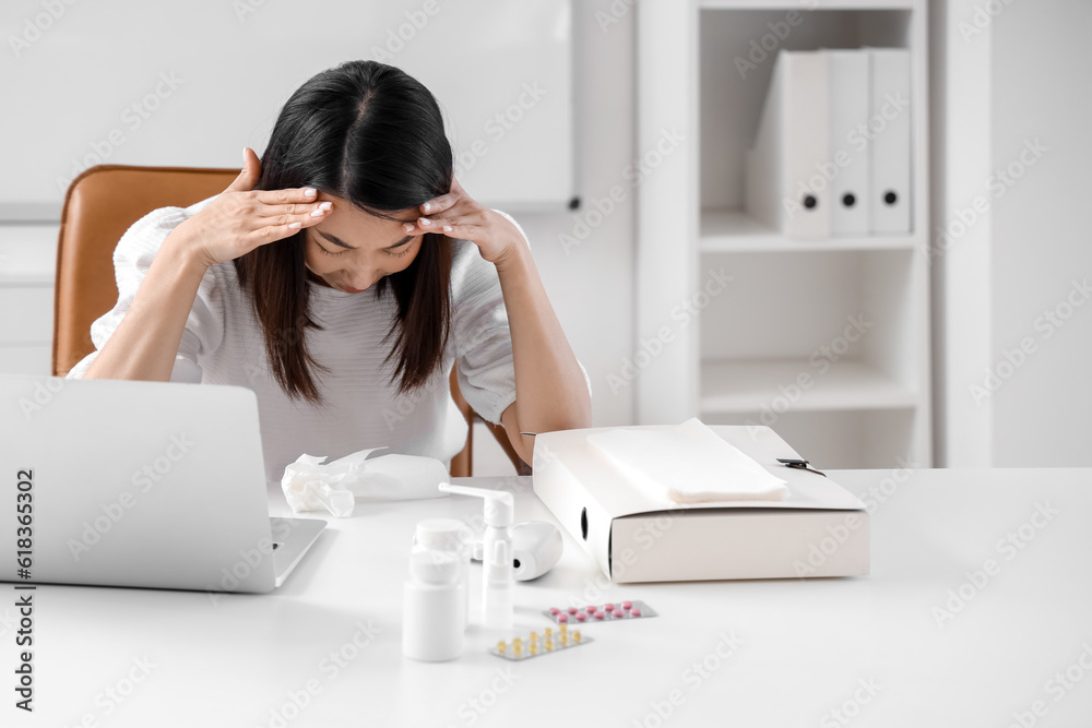 Ill Asian businesswoman working in office