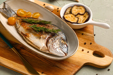 Plate with tasty grilled dorado fish on table