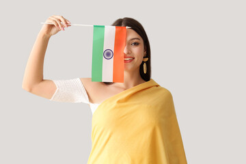 Young woman with Indian flag on light background