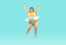 Happy Confident Fat Woman Having Fun At Beach Party On Summer Vacation Holiday. Plus Size Lady In Yellow Bikini, With Inflatable Rubber Floater Around Waist Dancing Isolated On Blue Background
