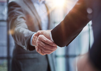 two diverse professional business men executive leaders shaking hands at office meeting