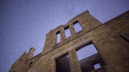 Wall Mural - Facade of an old abandoned building under the blue starry nighttime sky