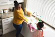 © Wavebreak Media - Happy african american mother and daughter dishwashing in kitchen
