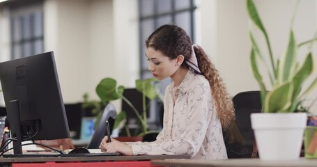 Wall Mural - happy biracial female creative using tablet at casual office, in slow motion