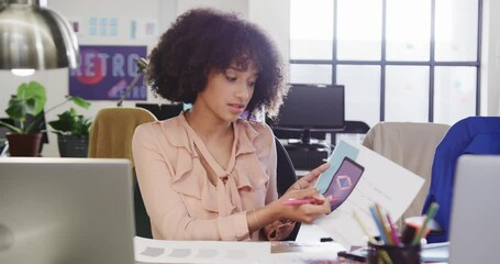 Wall Mural - portrait of african american female designer in video call at computer in casual office, slow motion