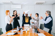 © jaimelafrickmartial  - Diverse business team smile in a well lit modern office as they celebrate the victoria.