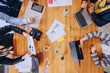 © jaimelafrickmartial  - Young multiehtnice businesspeople working together in meeting using laptop. Colleagues, startup office or teamwork concept. Top view, banner size with copy space.