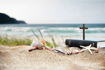 church summer retreat concept with bible book, cross of jesus christ and shells, conch and starfish 