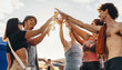 © Jacob Lund - Group of friends making a celebratory toast with beer at a summer festival