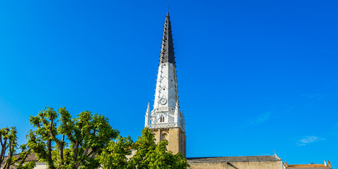 Wall Mural - Saint Etienne church and its black and white bell tower in Ars-en-Ré, France