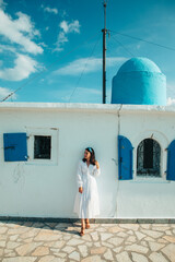 Wall Mural - beautiful woman in white dress near old greece church